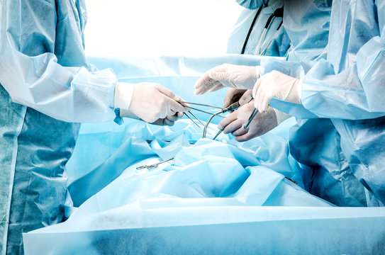 The process of work of surgeons during the operation. Doctors hold medical instruments.