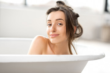 Obraz premium Close-up portrait of a young woman relaxing in the bathtube