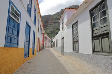 Foto op Aluminium AGULO, LA GOMERA, SPAIN: Cobbled street with colorful houses inside the village of Agulo © Christophe Cappelli