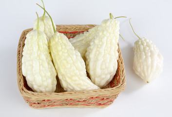 Bitter gourd in a bamboo basket isolated on white background
