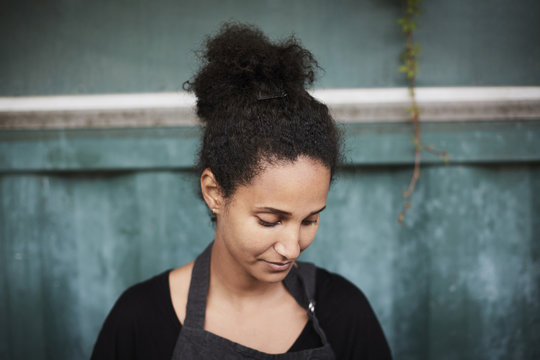 Young female gardener looking down at yard