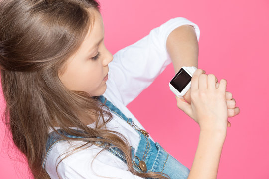 High angle view of cute little girl using smartwatch on pink