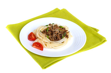Pasta nest tagliatelle with bolognese sauce on a plate on green napkin isolated on white background.