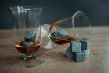 Stones for cooling whiskey and glases tulup on dark wooden background