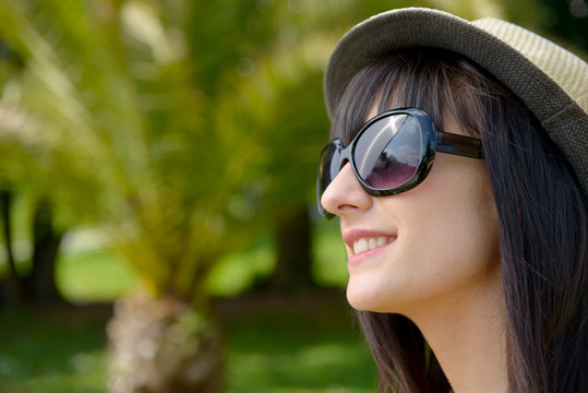 Young dark-haired woman with sunglasses in the park