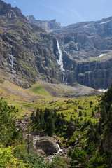 Picturesque Gavarnie waterfall falls into mountain valley in French Pyrenees landscape
