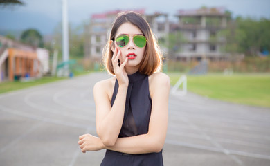 Fototapeta premium Fashion model Asian women Standing Poses and wear Black shirt. Short hair girl And wear sunglasses