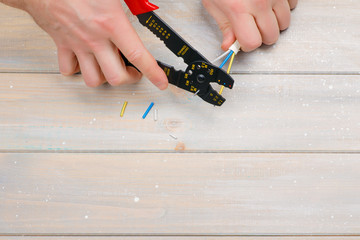 Cutting electric wires to the desired length with a special electrician tool.