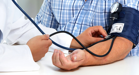 Doctor measuring blood pressure with sphygmomanometer