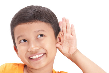 Little boy hearing something, hand to ear gesture on white background.
