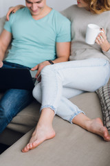 Fototapeta premium Couple enjoying lazy weekend together by reading and drinking coffee