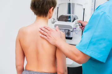Doctor Assisting Patient Undergoing Mammogram Test. Backview, selective focus