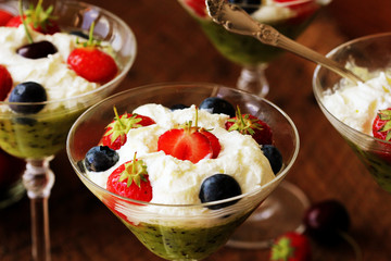 Desert with strawberry , blueberry, kiwi , cherry in glass of whipped cream
