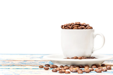 Full cup of coffee beans on the blue old wooden table. Isolated on white.