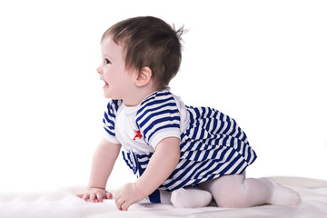 Fototapeta premium cute little baby girl in blue-white dress, crawling, laughing and playing at studio, isolated on white