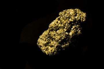 Iron sulphide on black background. Isolated. Similar like gold.