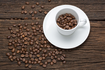 Coffee beans in cup on wooden table