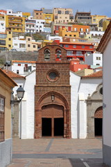 Fototapeta premium SAN SEBASTIAN DE LA GOMERA, LA GOMERA, SPAIN: Church of the Assumption in San Sebastian de la Gomera with colorful houses in the background