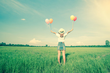 asian woman with balloon in grass field