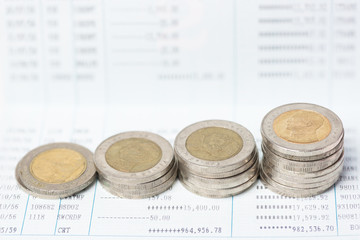 Close up Stack of coins on the account book in selective focus.