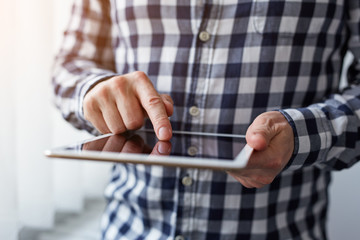 Man in a checkered shirt using digital tablet