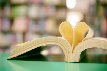 book page in heart shape with library background, love in valentine day