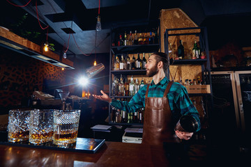 The barman juggler throws up a glass for  cocktail at bar.