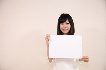 Fototapeta premium ホワイトボード（スケッチブック）を持つ女性