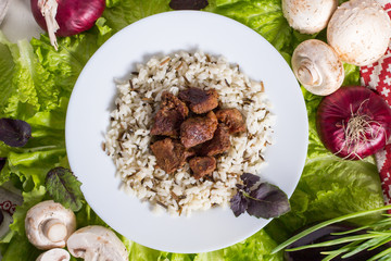 pork pieces with a garnish from brown rice