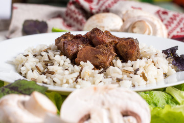 pork pieces with a garnish from brown rice