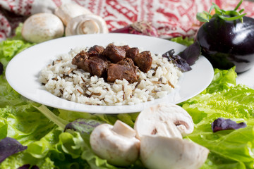 pork pieces with a garnish from brown rice