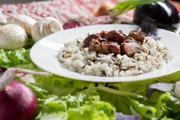 pork pieces with a garnish from brown rice