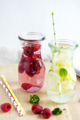 Detox water with raspberries and lemon mint on a light background
