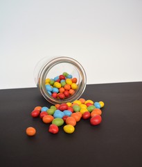 chocolate lentils in a jar on a black ground with colored background