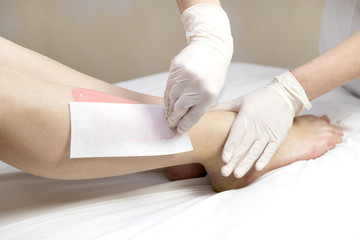 Obraz premium Process depilation female legs and hands in a beauty salon