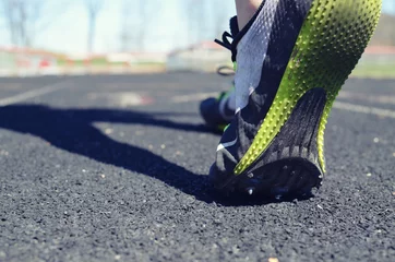 Zelfklevend Fotobehang Athlete walking on track with spike shoes on during team practice. © ccestep8