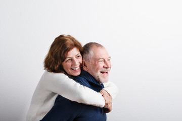 Beautiful senior couple in love hugging. Studio shot.