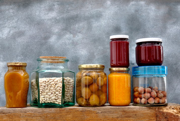 Jars with jam and nuts on the shelf