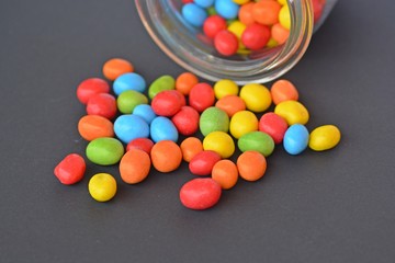 chocolate lentils in a jar on a black ground with colored background