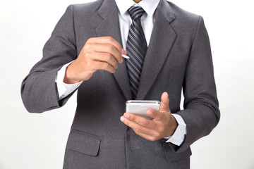 young asian businessman wearing gray suit using mobile smart phone with touch pen over white background