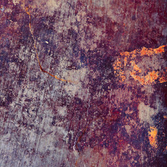 Rusty metal plate with colored spots of corrosion