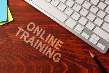 Online training written on a wooden surface. E-learning concept.