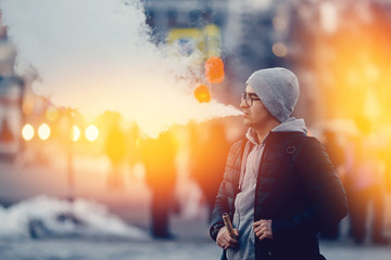 vaping man holding a mod device. cloud of vapor. Vape. high contrast and monochrome color tone.