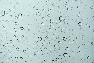 Rain drops on window glasses surface with cloudy background .