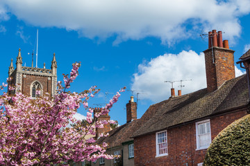 Old English Church tower and houses on a sunny Spring day
