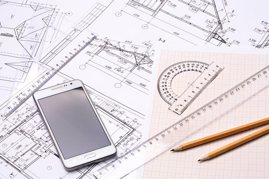 Workplace of architect. Architectural design, graph paper, drawings, simple pencil, transparent ruler with protractor, sketch and smartphone on the table