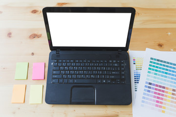 Fototapeta premium graphic designer desk table with computer, sticky note and color guide palette swatches