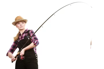 Fotobehang Focused woman in sun hat holding fishing rod © Voyagerix
