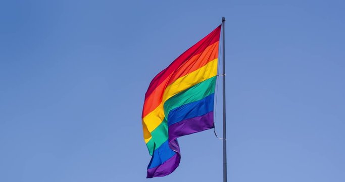 Slow motion gay pride flag blowing in the wind.