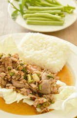 Thai spicy chop pork salad eat couple with sticky rice and fresh vegetable